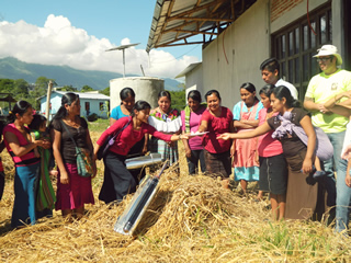 Mexicans passing plate of food over haystack