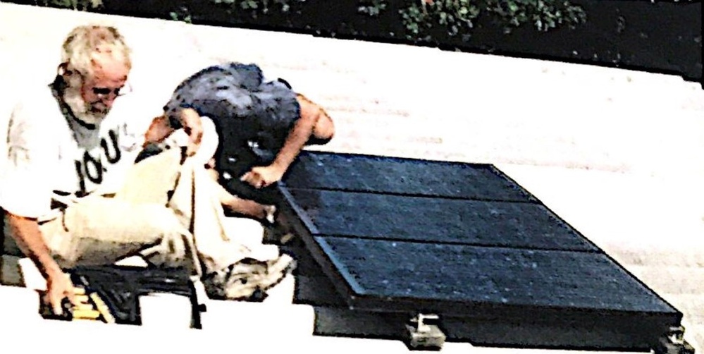 Scanned photo of Allen repairing solar power system at Honduran clinic in 2000